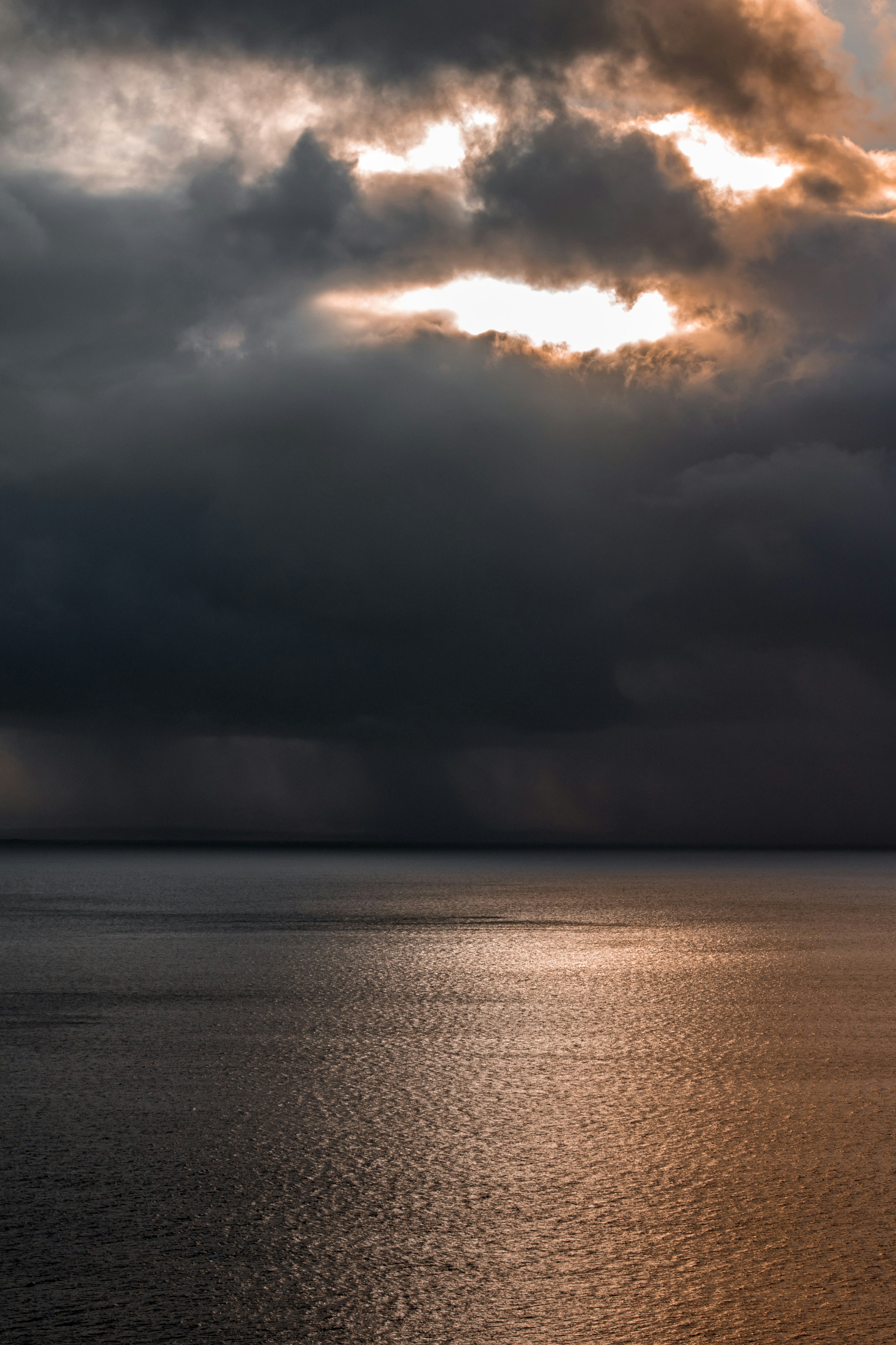 body of water under cloudy sky during sunset